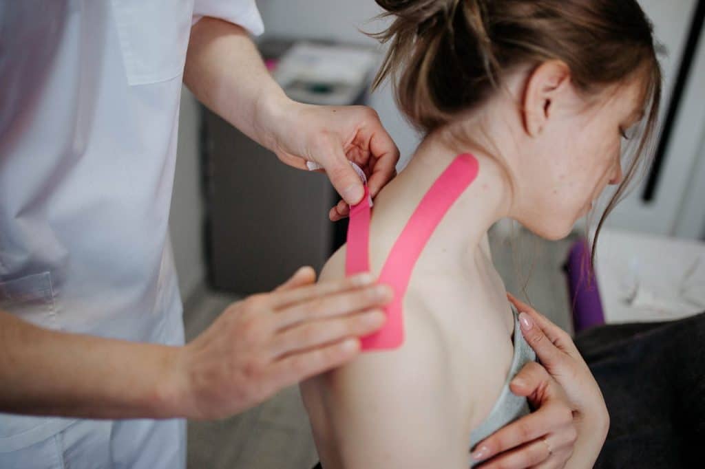 Person Making Taping to Woman's Neck